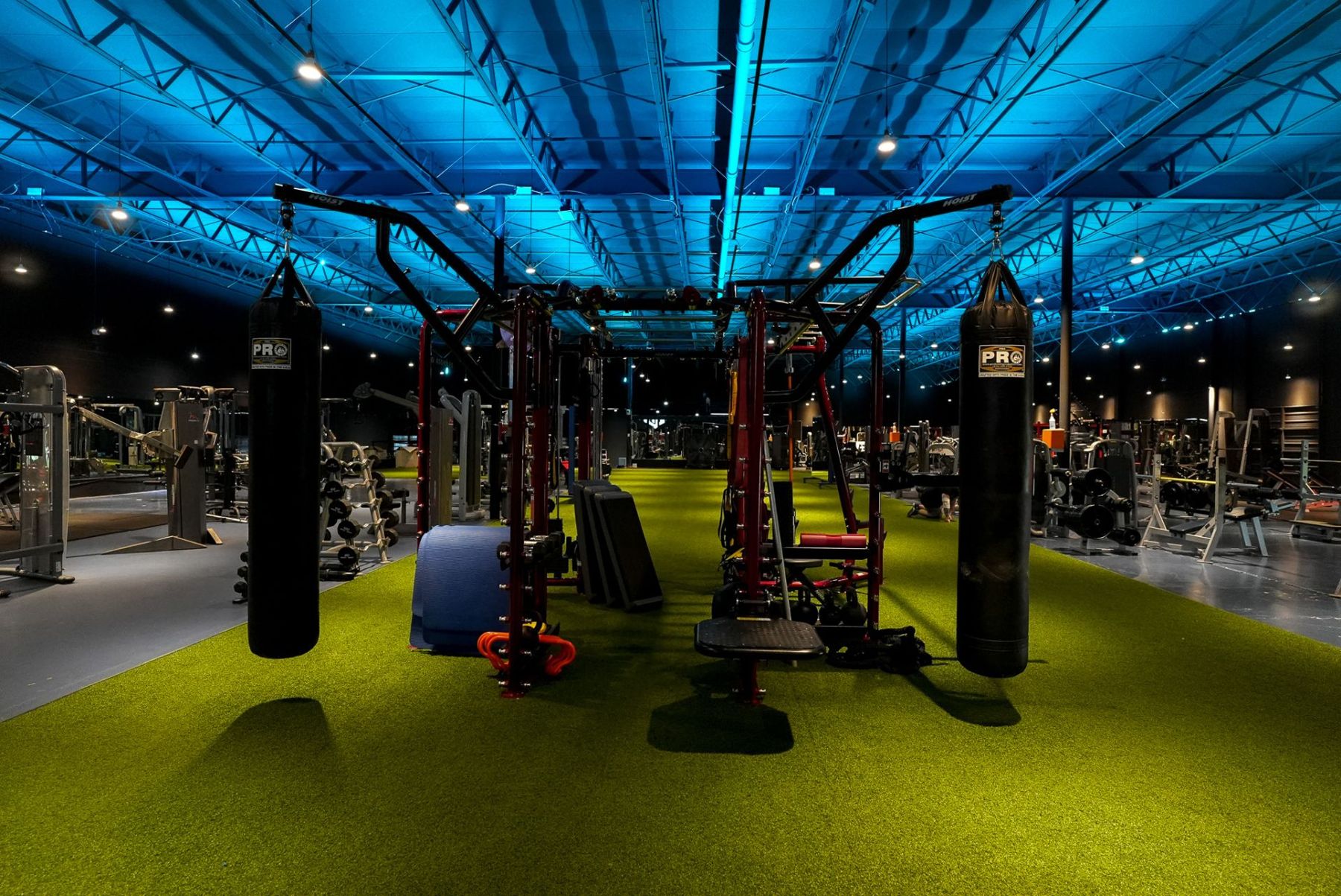 Turf strip with cable stations and heavy bags under blue light